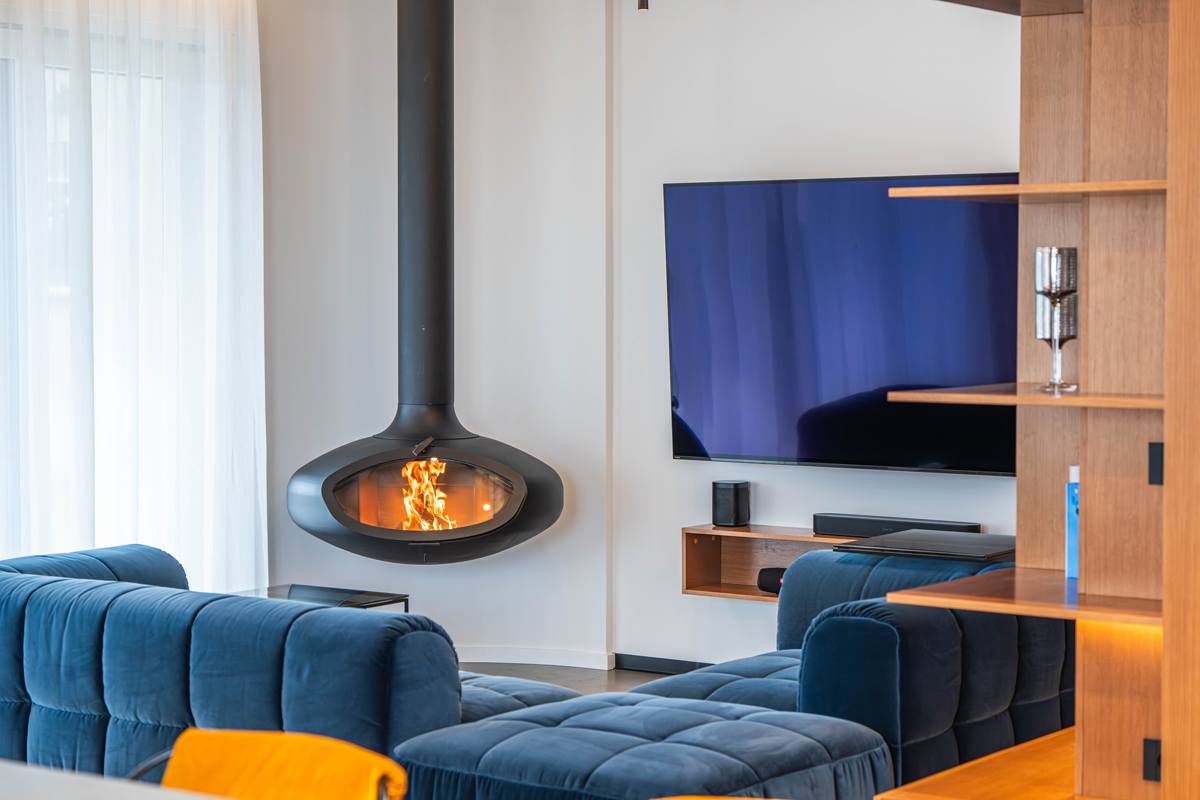 firebob hanging in contemporary living space. blue sofas and tv hanging on the wall.