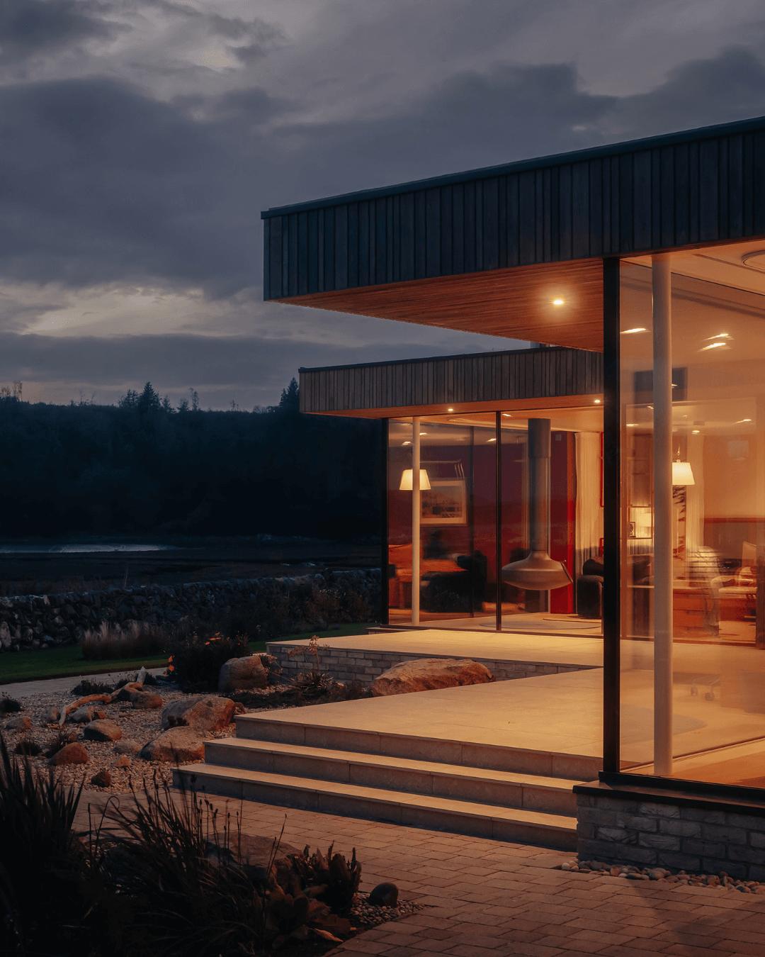 Tidal House exterior shot in the evening, stunningly lit up with interior lighting.