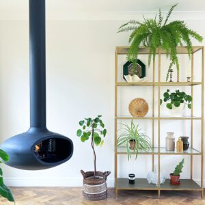 Suspended BioBob bioethanol fireplace in a contemporary living room surrounded by indoor plants. The handcrafted ceiling mounted fireplace creates a warm focal point, complementing the natural greenery and modern interior with a calm, inviting atmosphere.