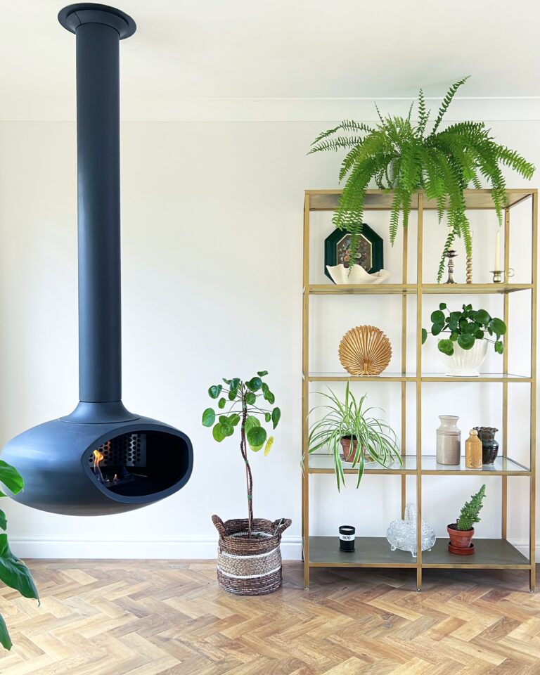 Suspended BioBob bioethanol fireplace in a contemporary living room surrounded by indoor plants. The handcrafted ceiling mounted fireplace creates a warm focal point, complementing the natural greenery and modern interior with a calm, inviting atmosphere.