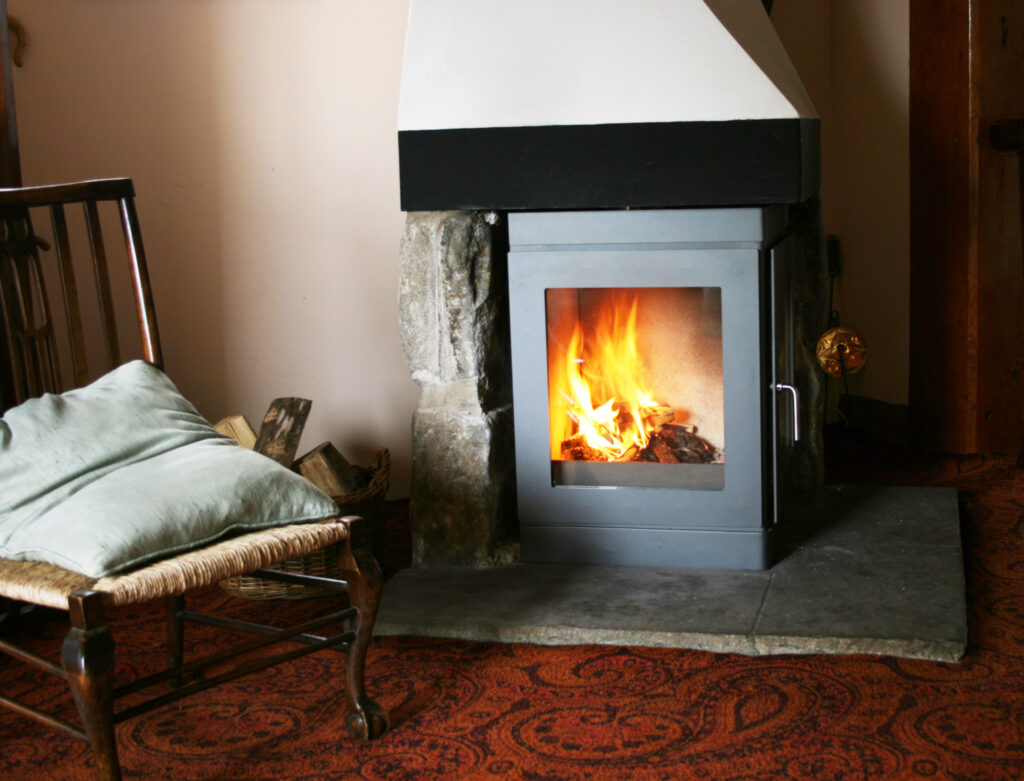 image of a fireplace in a lounge with an armchair.