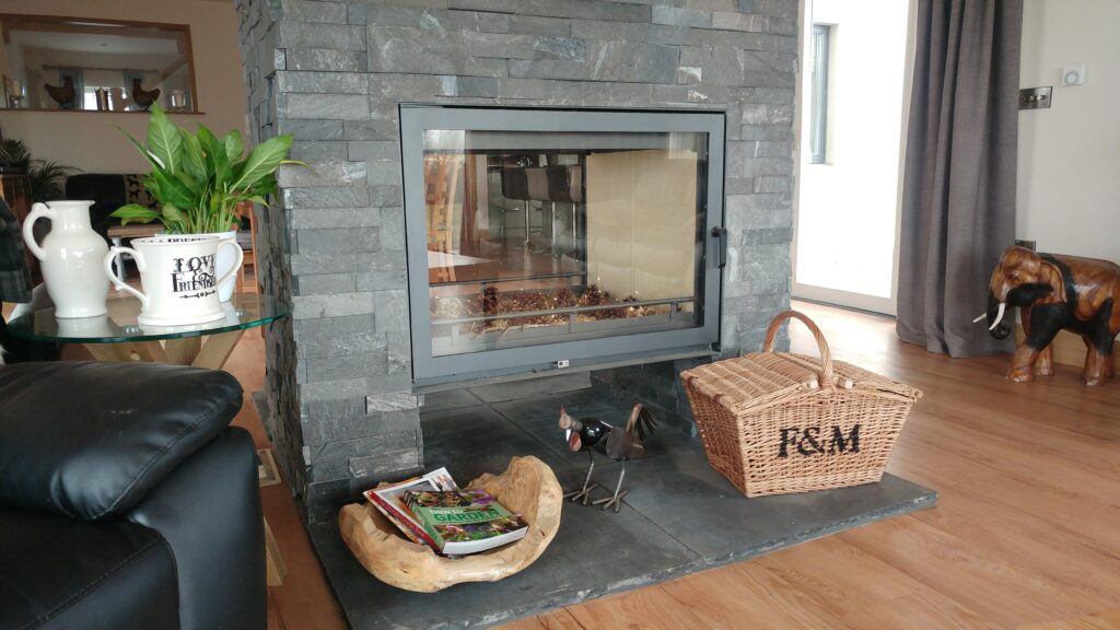 Image of a fireplace in the wall, plants and other decorative items placed around.