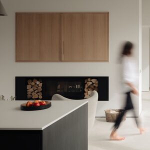 Woman walking through a contemporary home. The modern interior features clean lines, natural light and a warm, inviting atmosphere.