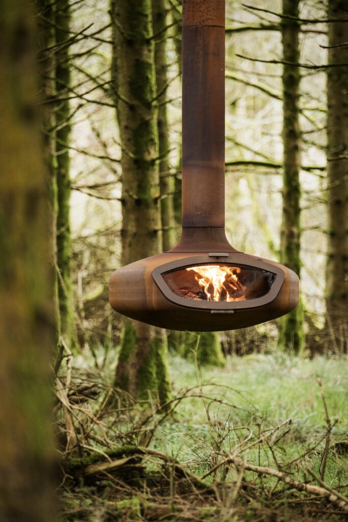 Suspended outdoor Firebob, wood-burning stove. Woodland background.